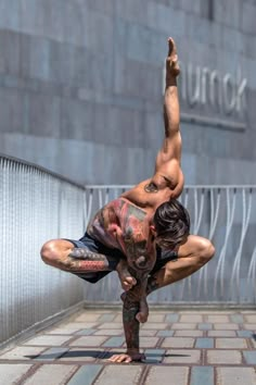 a man doing a handstand in front of a building