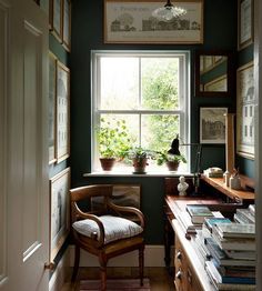 a chair sitting in front of a window filled with lots of books on top of a wooden desk