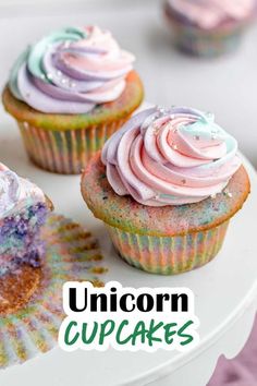 three cupcakes with unicorn icing and sprinkles sitting on a plate