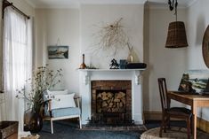 a living room filled with furniture and a fire place in front of a fireplace covered in wicker baskets