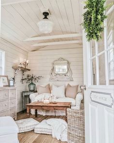 a living room filled with furniture and a mirror on the wall next to a window