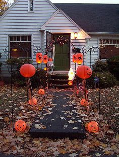 a house decorated for halloween with pumpkins and lights