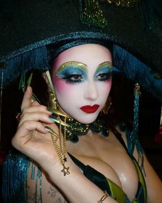 a woman with makeup on her face is dressed in costume