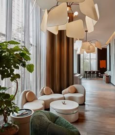 a living room filled with lots of furniture next to a tall window covered in curtains