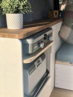 a potted plant sitting on top of a wooden shelf next to a stovetop oven