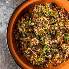 a bowl filled with meat and veggies on top of a stone countertop