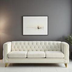 a white couch sitting next to a lamp in a living room