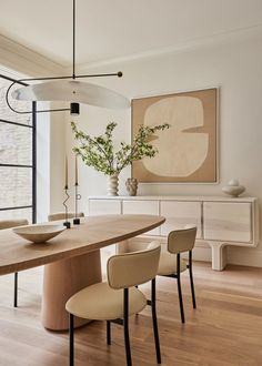 a dining room table with four chairs and a bowl on it's centerpiece