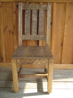 a wooden chair sitting in front of a wall