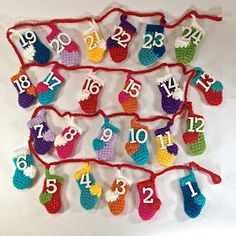 a crocheted christmas stocking hanging on a red string with numbers and stockings