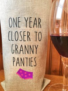 a wine glass next to a bag with the words, one year closer to granny pannies