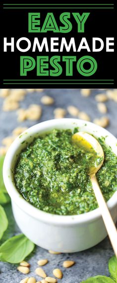 homemade pesto in a white bowl with a wooden spoon and green leaves around it