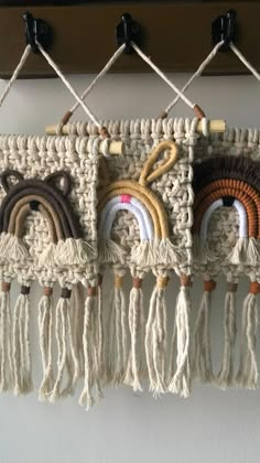 there is a crocheted wall hanging with different colors and designs on the hooks