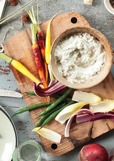 an assortment of vegetables and dip on a cutting board