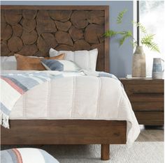 a bed with wooden headboard and pillows on it