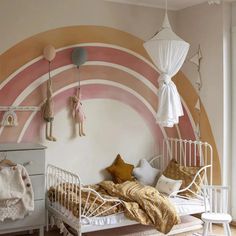 a child's bedroom decorated in pink, yellow and white with an arch painted on the wall