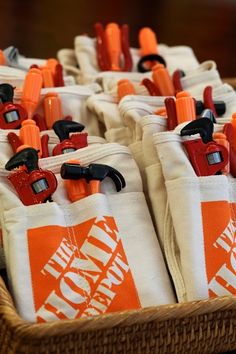 several orange and white bags with handles in a wicker basket on top of a table