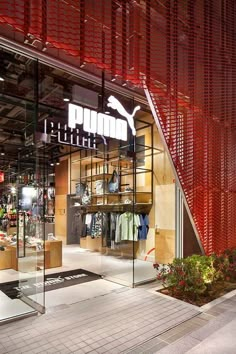 the inside of a puma store with its glass walls and red metal slats