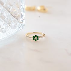 The vibrancy of this emerald flower ring is breathtaking! Emerald represents so many great qualities and is an essential piece in your jewelry collection! This flower ring pairs the beauty of nature just perfectly! The emerald stones are a beautiful vibrant color and it's set against radiant and brilliant cubic zirconia stones that shine so bright. This ring is minimalist and dainty, and great for stacking or worn alone. Makes a great gift to yourself or someone special! At Sami Jewels, we belie Green Flower-shaped Jewelry For Anniversary, Green Flower Shaped Anniversary Jewelry, Green Flower-shaped Anniversary Jewelry, Fine Jewelry Flower Ring With May Birthstone Gemstone, Fine Jewelry Round Flower Ring With May Birthstone, Fine Jewelry May Birthstone Flower Ring, Fine Jewelry With Green Flower-shaped Gemstones, Fine Jewelry In Green With Flower Shape, Fine Jewelry In Flower Shape And Green Color