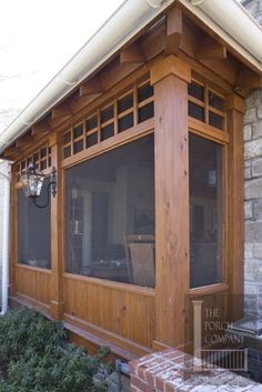 an outside view of a house with wood trimming and large windows on the side