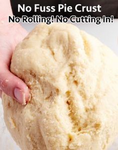 a person holding a ball of dough in their hand with the words no fuss pie crust on it