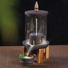 a miniature model of a fountain made out of wood and glass with a wooden base