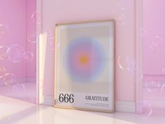 an art piece with bubbles floating in the air next to a framed poster that reads 666 gratitude