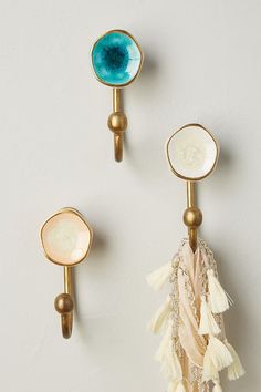 three pairs of earrings with blue and white stones on the end, one in gold