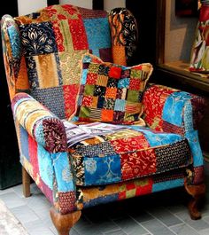 a colorful patchwork chair sitting in front of a mirror