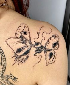 a woman with a tattoo on her back has a dragon and butterfly design on it