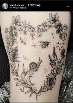 a woman's thigh with flowers and birds in the shape of a heart