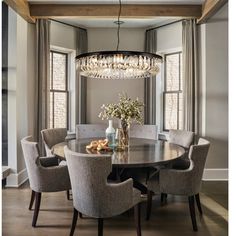 a dining room table with chairs and a chandelier hanging from it's ceiling