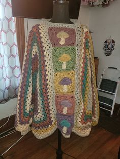 a crocheted jacket is sitting on a mannequin's head stand