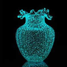 a blue vase with water droplets on it's surface in front of a black background