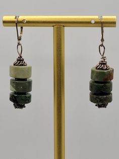 These are gorgeous handmade green gemstone earrings.  ATTRIBUTES - Marked 925 sterling leverback hooks for pierced ears - Artisan handmade  - We believe this is green jasper based off research, but we are not gemologists - Stones are cold to the touch - Stacked round green stones with sterling findings  - Beautiful condition with minor wear from gentle use MEASUREMENTS - 1.90" long x 0.47" wide CONDITION - Excellent GENTLY USED condition with minor wear MORE BEAUTIFUL EARRINGS - https://www.etsy.com/shop/SiftedandRefined?section_id=32269566 BACK TO OUR STOREFRONT - https://www.etsy.com/shop/SiftedandRefined SPECIAL NOTE - Props such as trays, display stands, jewelry boxes, rulers, or coins are not included SHIPPING - We package items in organza or velvet gift bags - included FREE - Orders Green Jade Earrings With Natural Stones, Green Artisan Dangle Earrings, Adjustable Jade Jewelry With Ear Wire, Adjustable Jade Earrings With Ear Wire, Green Artisan Gemstone Earrings, Artisan Green Drop Earrings, Green Gemstone Artisan Earrings, Artisan Green Gemstone Earrings, Green Natural Stone Drop Earrings