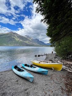 two canoes sitting on the shore of a lake