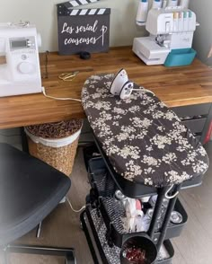 an ironing board sitting on top of a wooden table next to a sewing machine