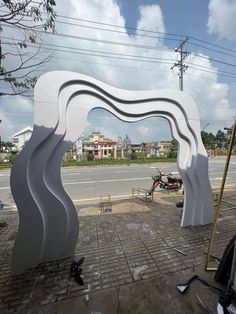 a large white sculpture sitting on the side of a road