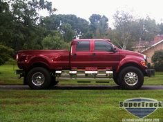 a red pickup truck parked on the side of a road in front of a house