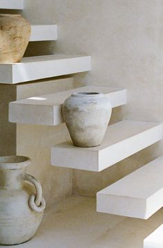 three vases sitting on top of white steps