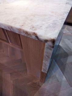 a marble counter top with wooden cabinets in the background