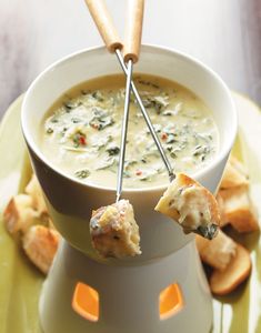 a white bowl filled with soup and some bread sticks sticking out of the top of it