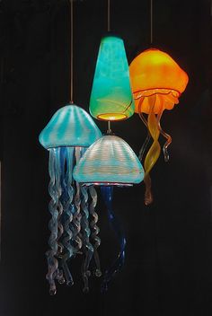 three different colored lamps hanging from strings in the dark room with jellyfishs on them