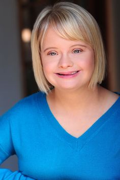 a woman with blonde hair wearing a blue sweater