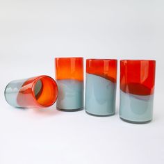 three different colored glass vases sitting next to each other