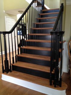 a set of stairs with black railings and wood handrails in a home