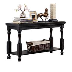 a black table with books, vases and pictures on it next to a wicker basket