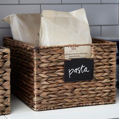 two wicker baskets with labels on them sitting on a countertop next to coffee bags