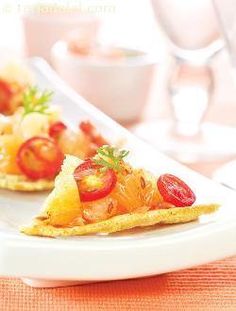 two small pieces of food on a white plate with utensils in the background