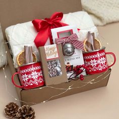 a christmas gift box with coffee mugs and cookies